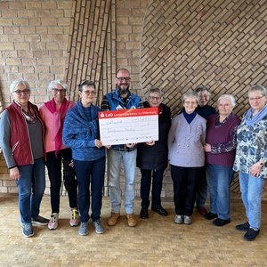 Die Frauen des Handarbeitskreises überreichen den Spendenscheck an Kai Niemann von der Bahnhofsmission. Foto: Johanne Logemann